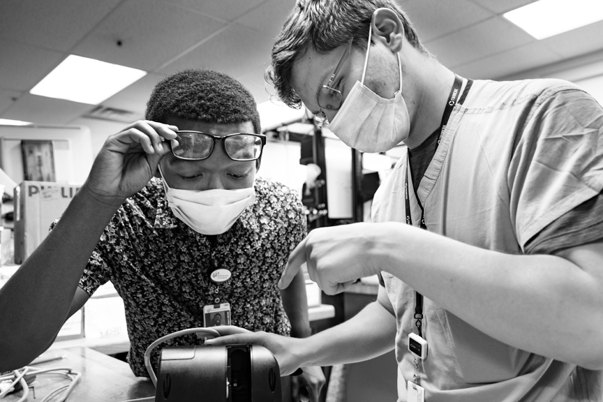 Kybaree is intently looking at something an employee is showing him.