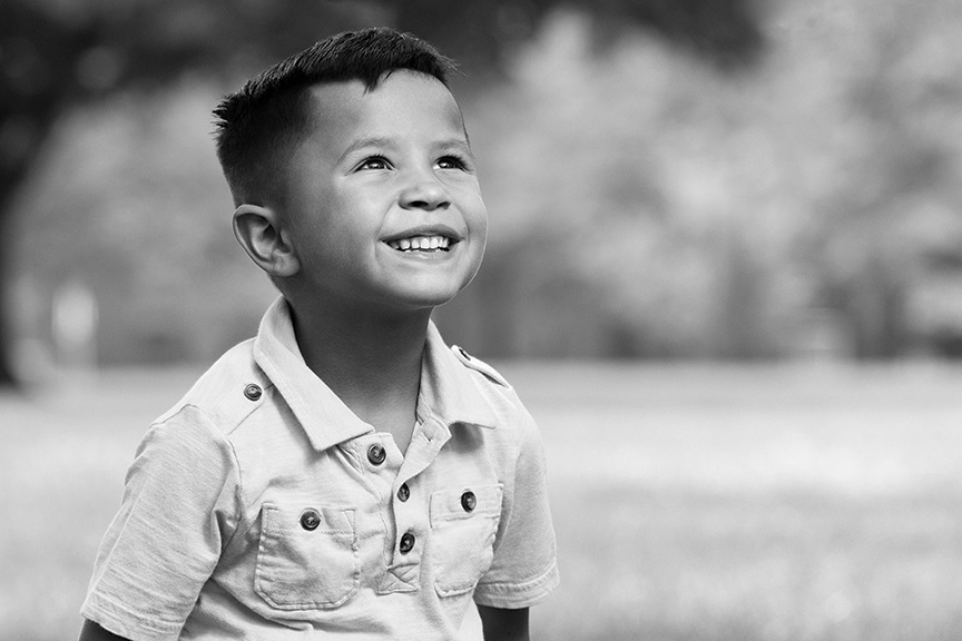 Child smiling looking up at the sky because he is now healthy due to generosity of donors.