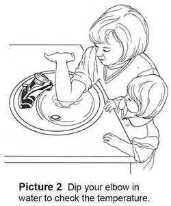 Parent dipping elbow in water to check temperature