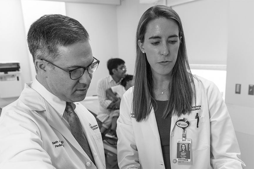 Two doctors looking down at computer