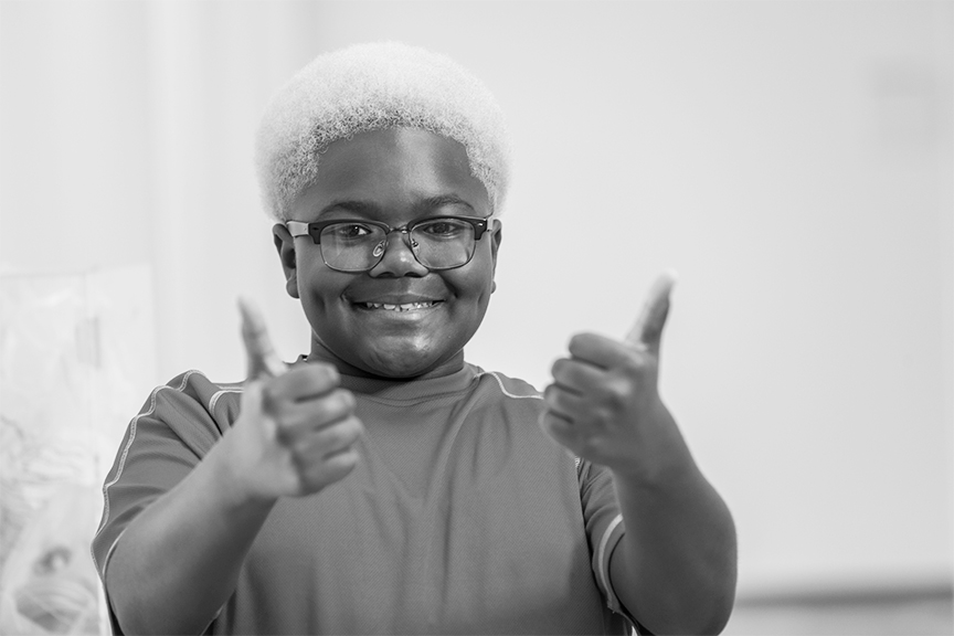 Little boy holing two thumbs up